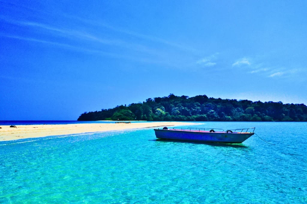 Traditional boat sailing through azure waters - explore hidden coves with customized Andaman packages
